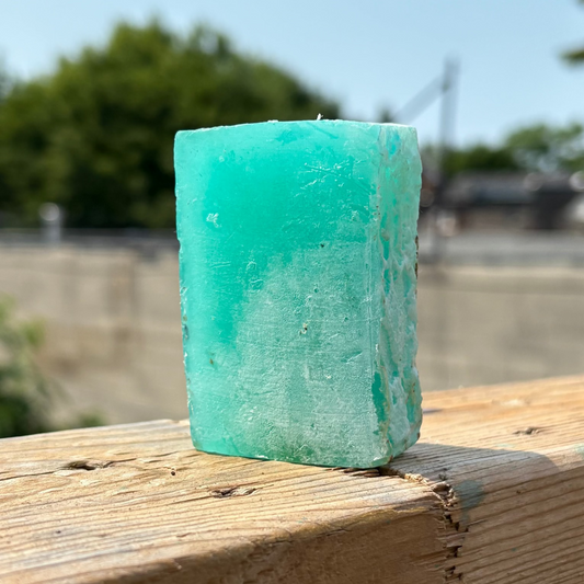 Sea green dreadlock shampoo bar on a coastal-inspired railing wrapped in nautical fishing rope.