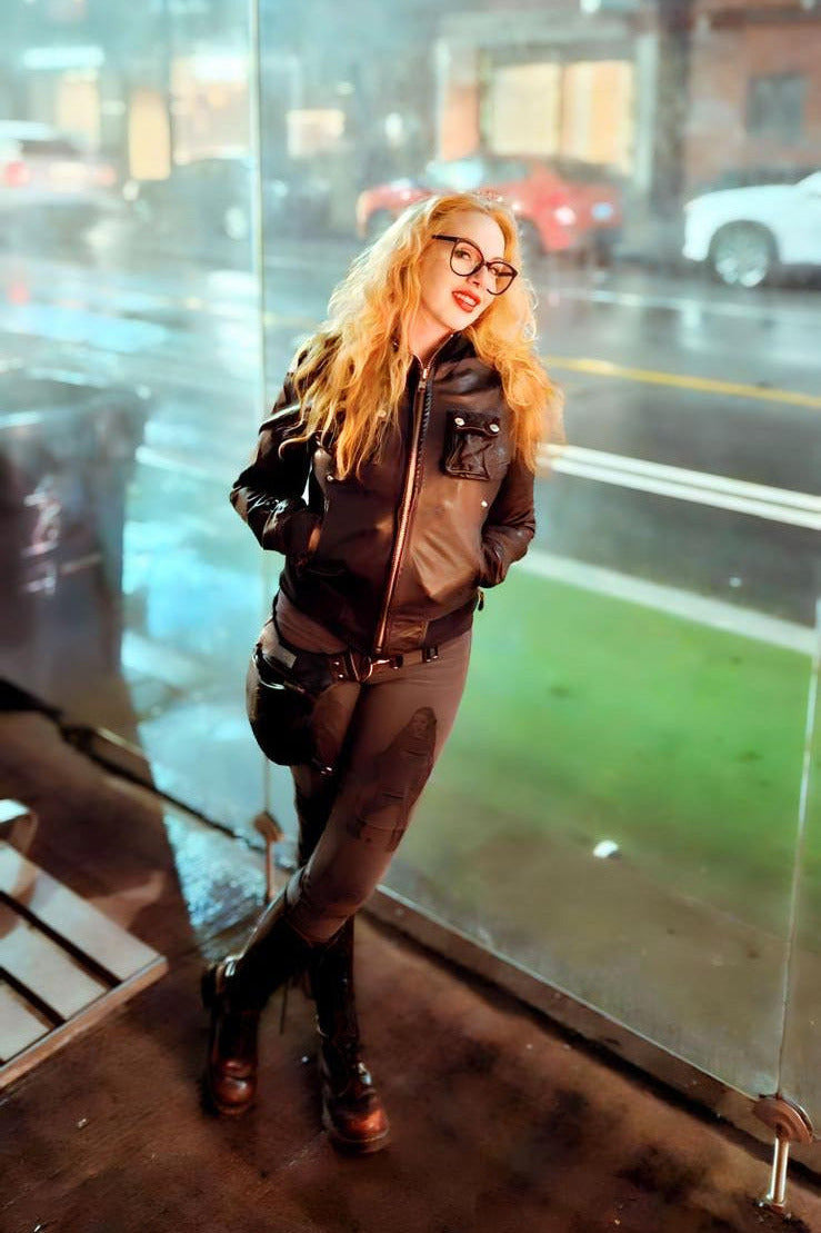Person standing in front of a glass door with a city street reflection.