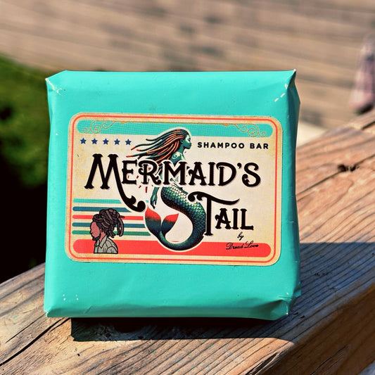 Mermaid's Tail shampoo bar packaging on a wooden surface with a blurred natural background