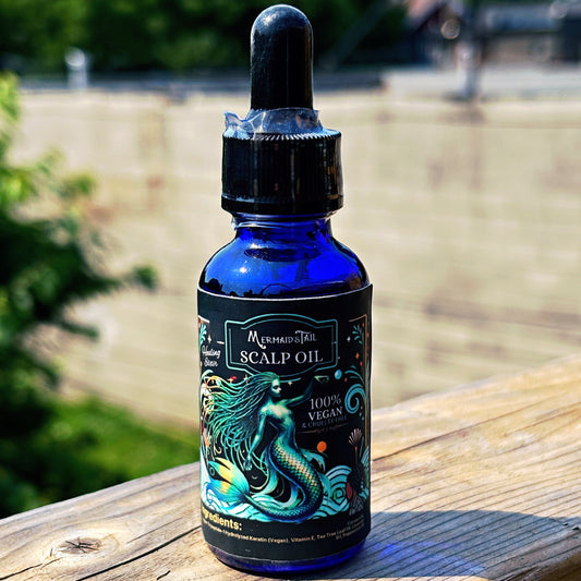 Blue bottle of scalp oil with a mermaid design on a wooden surface outdoors