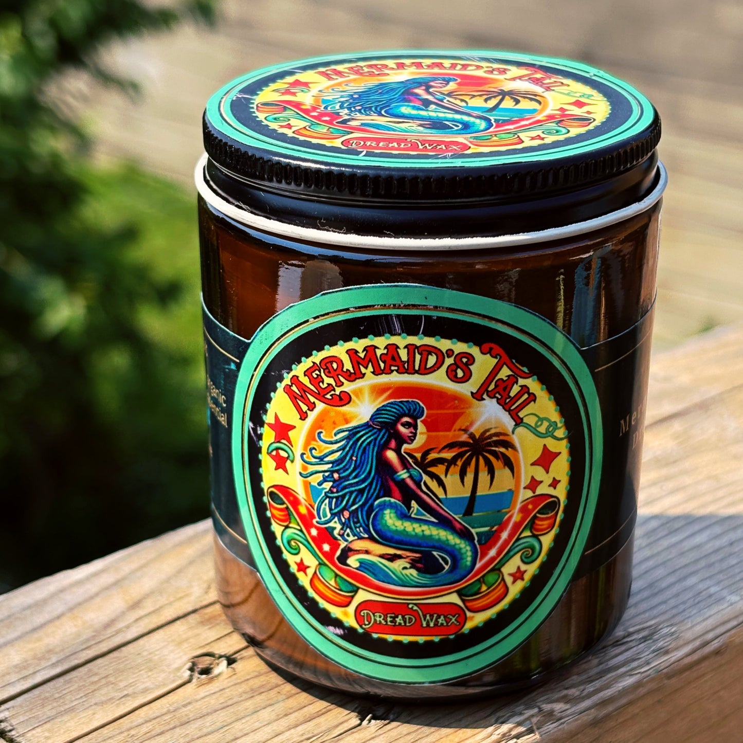 Jar of pigmented for darker hair Mermaid's Tail Dread Wax on a wooden surface with a blurred natural background