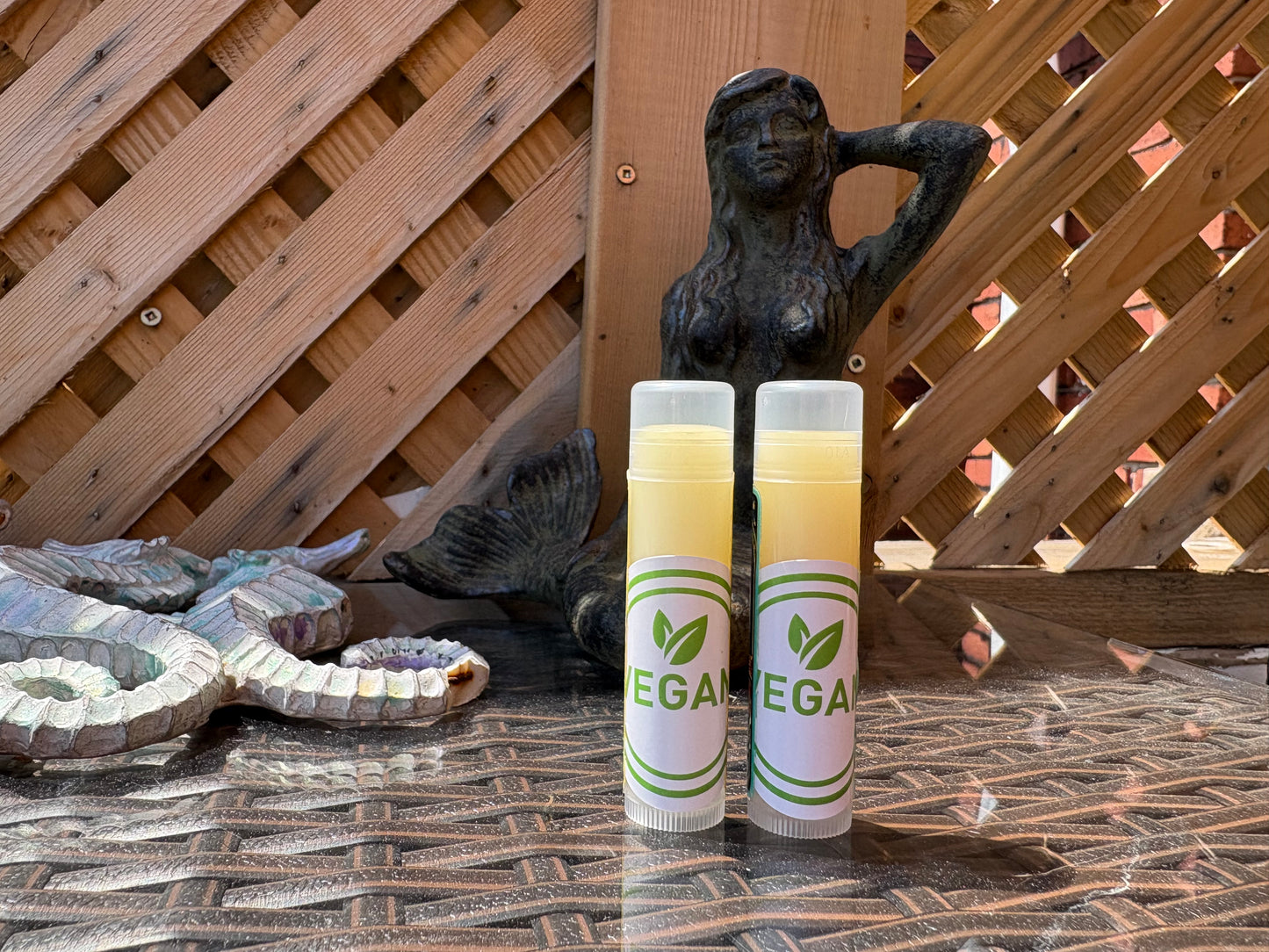  Two Dread Love Vegan Nourishing Lip Balm tubes on an outdoor table 
