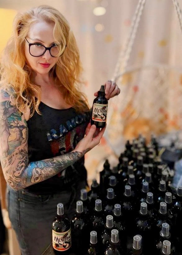 Krista Pettipas, founder of Dread Love and known as The Dread Wizard, standing in her Toronto, Ontario studio surrounded by her Sea Spray. A proud Canadian loctician with over 20 years of experience.