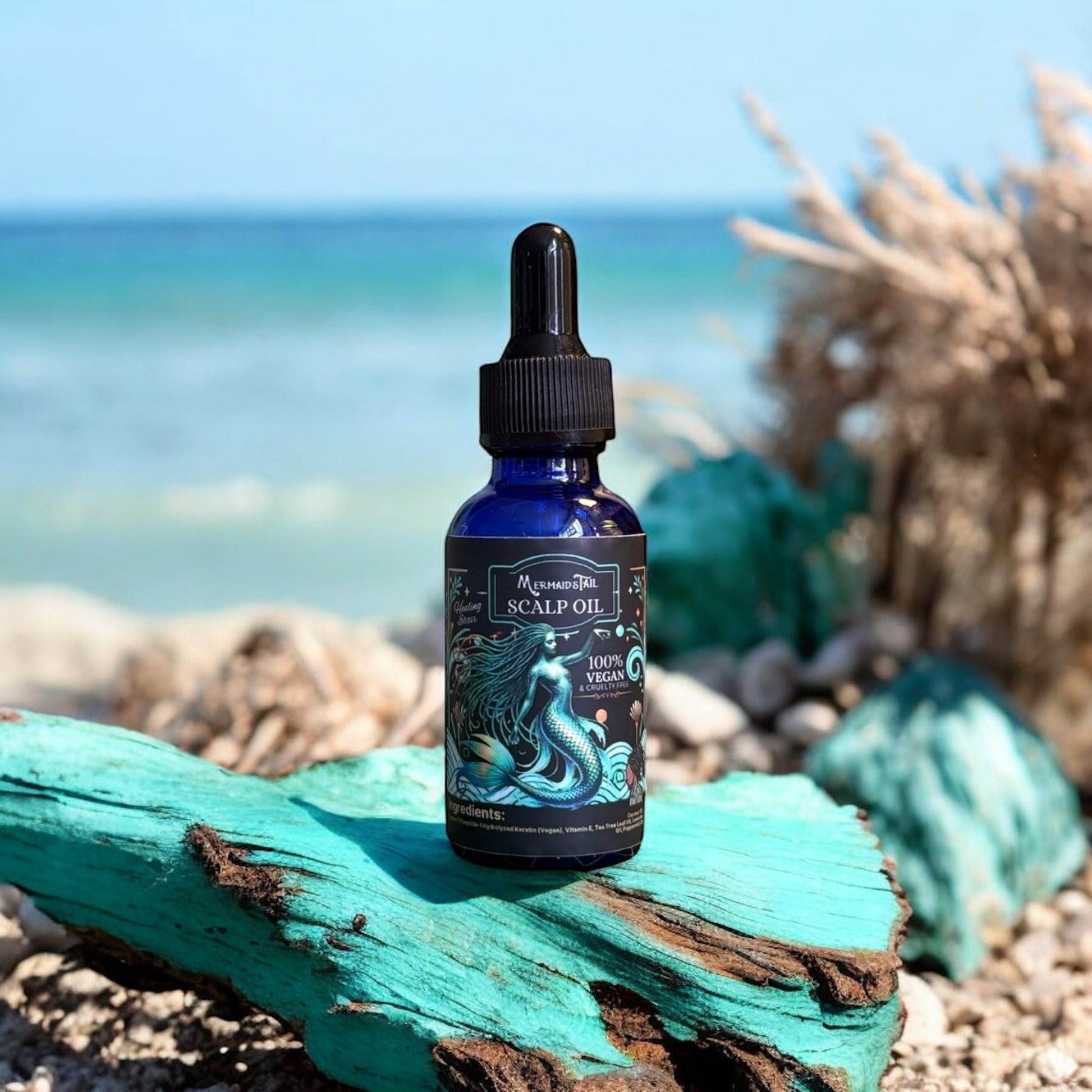 Bottle of scalp oil on a piece of driftwood with a beach background