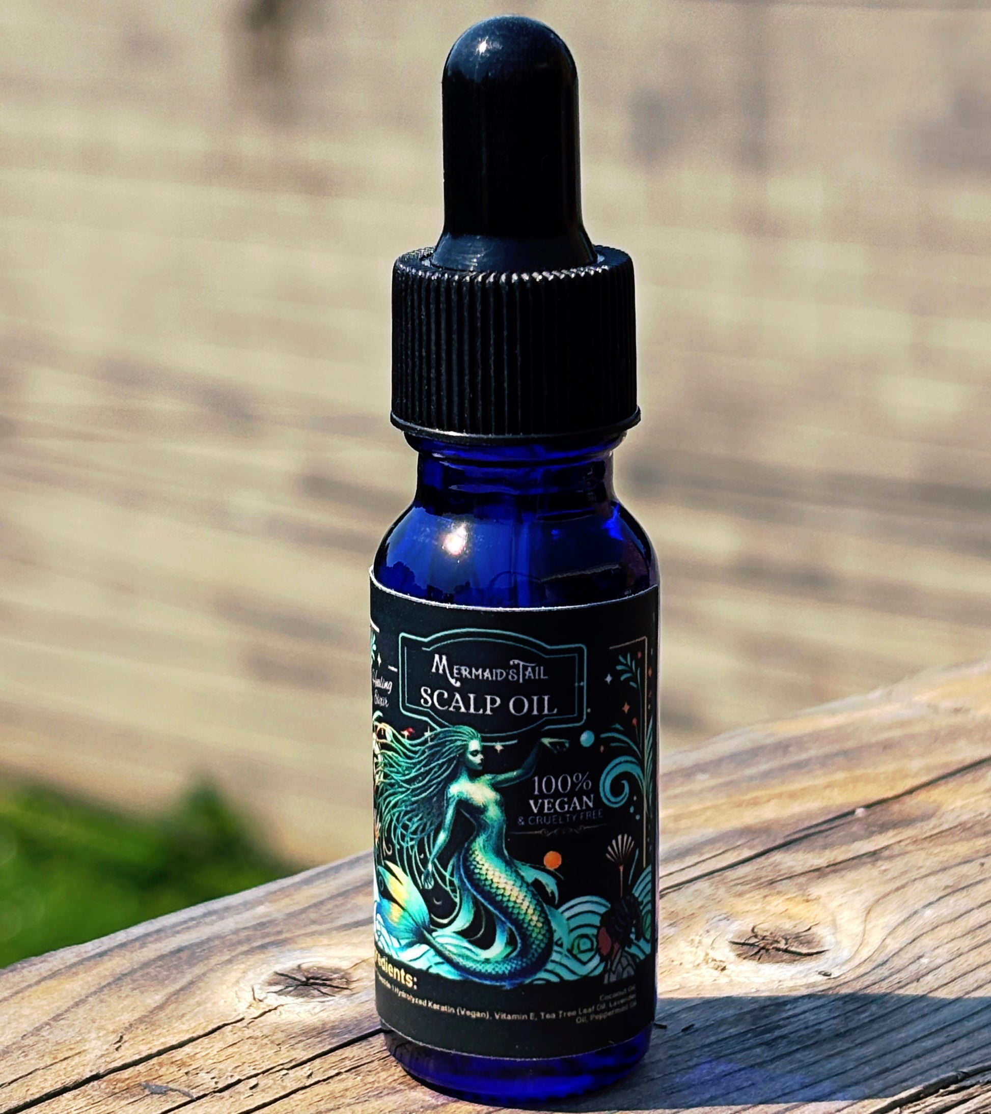 Blue bottle of scalp oil with a dropper on a wooden surface