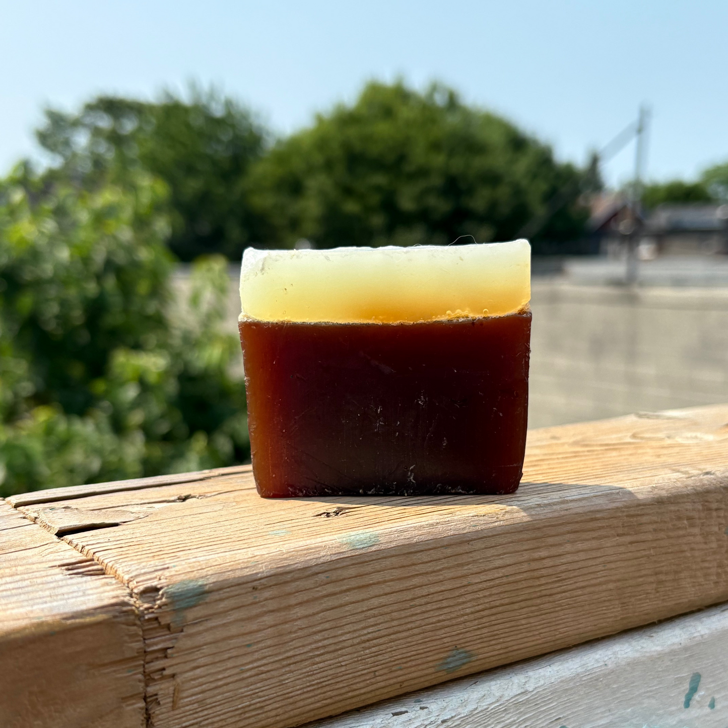 Bar of soap on a wooden surface with a blurred natural background