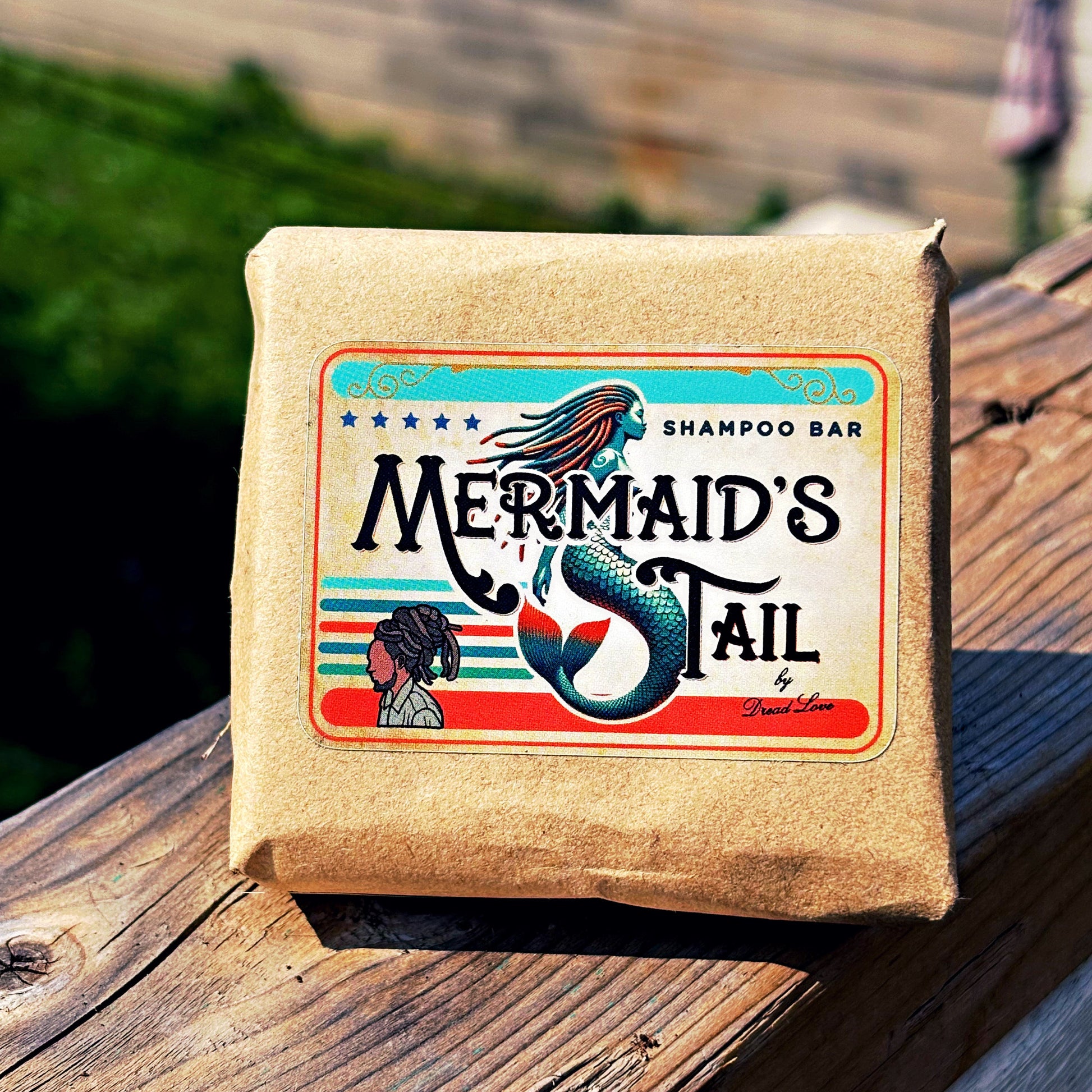  Mermaid's Tail Branded Eco-wrapped shampoo bar displayed on a hand-wrapped nautical rope railing in natural light.