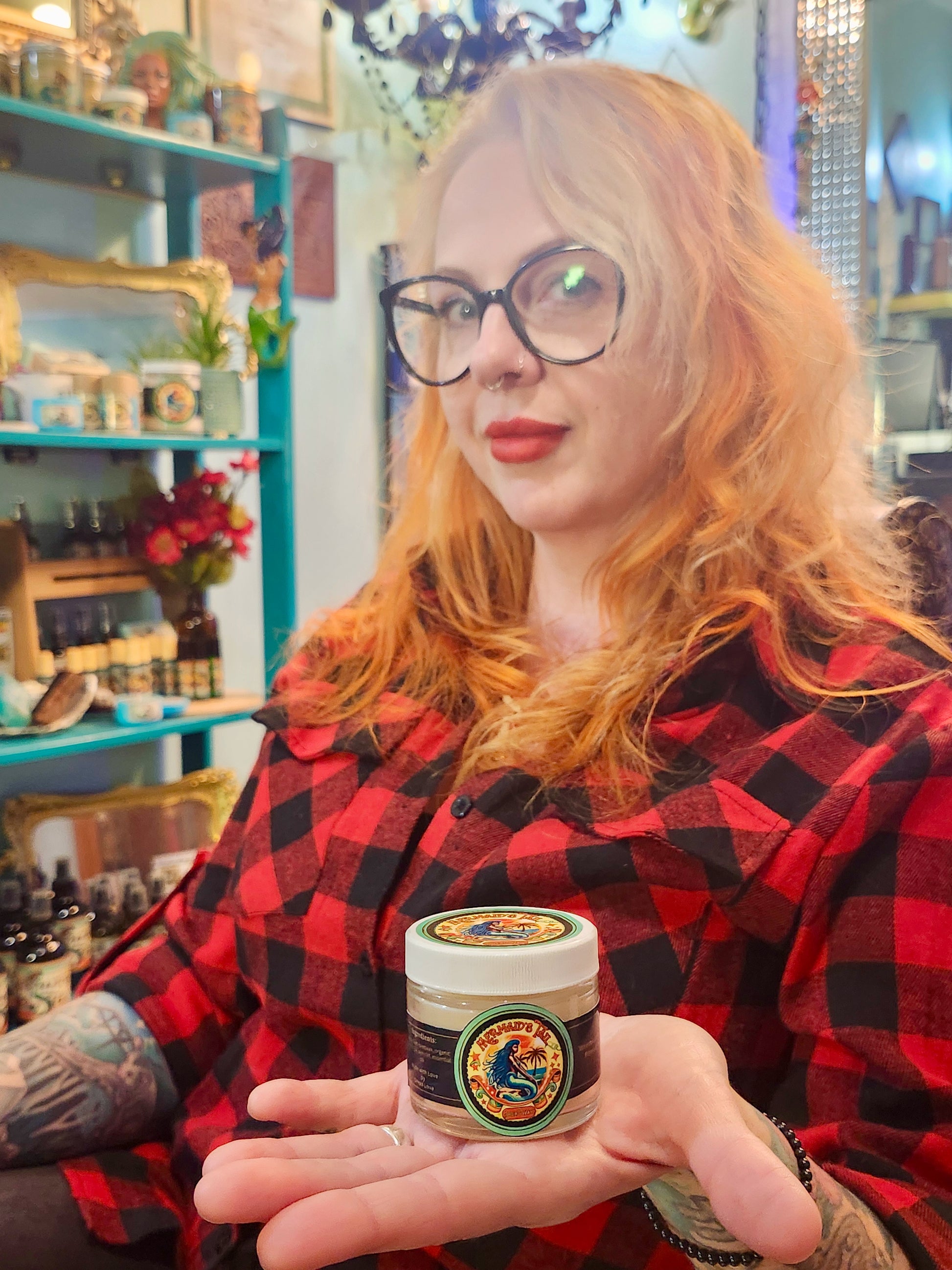 Krista, licensed loctician and owner of Dread Love, holding Mermaid’s Tail Residue-Free Dreadlock Wax in a reusable glass jar at her salon.
