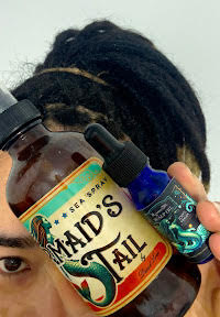Client holding Dread Love Sea Spray and Scalp Oil to tighten dreadlocks and soothe scalp