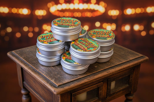 Multiple small containers lip balms with colorful labels on a dark surface