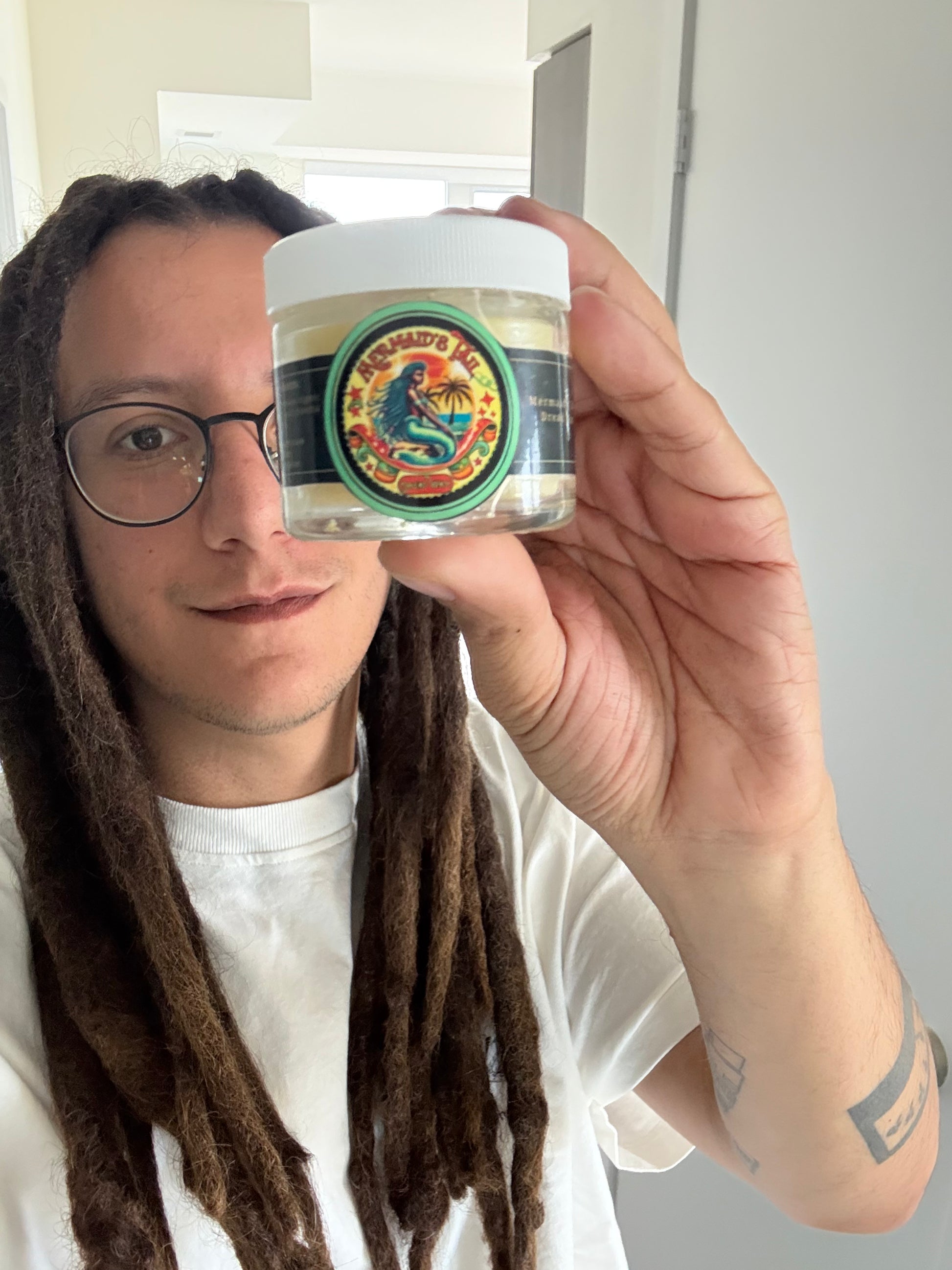 Oupsing holding Dread Love’s residue-free dreadlock wax — breathable hold for neat, frizz-free locs.